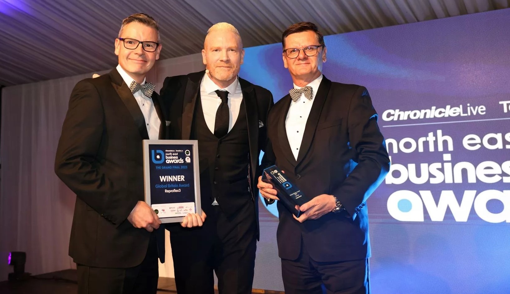 Andrew Hewitson R3 Group CEO with award host Iwan Thomas MBE and R3 Co-founder Trevor Lowes at the Grand Final of the North East Business Awards 2023.